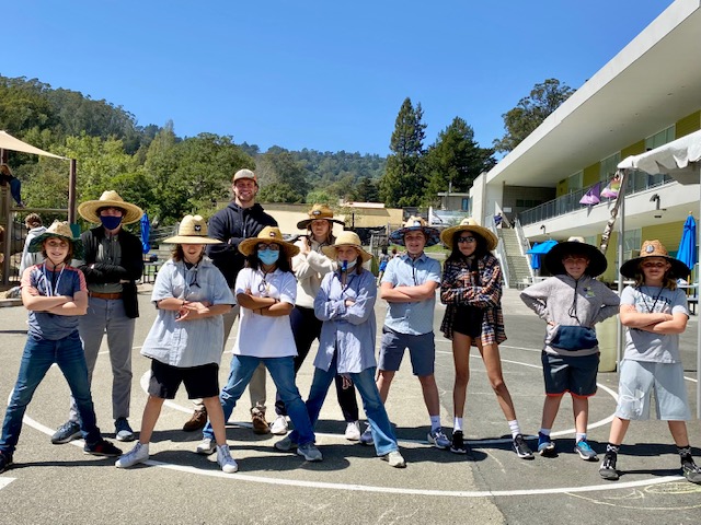 Students and adults posing together in a sunny school courtyard
